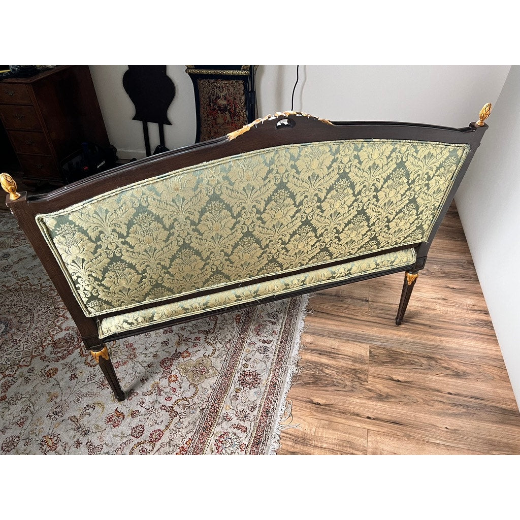 A Vintage Louis XVI Style Settee in Green Damask Upholstery sits on a hardwood floor beside a patterned area rug and antique furniture. Brand: None and/or Unknown.