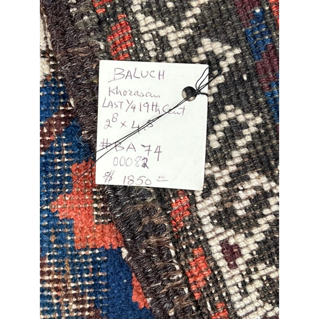 A close-up of an Antique Baluch Rug from the Khorasan Region, NE Persia, c. late 19th century (2’8 x 4’5), with a handwritten label reading: “BALUCH, Khorasan, LAST 1/4 19th Cent, 2 x 4, #BA74, 00082, $1850.”.