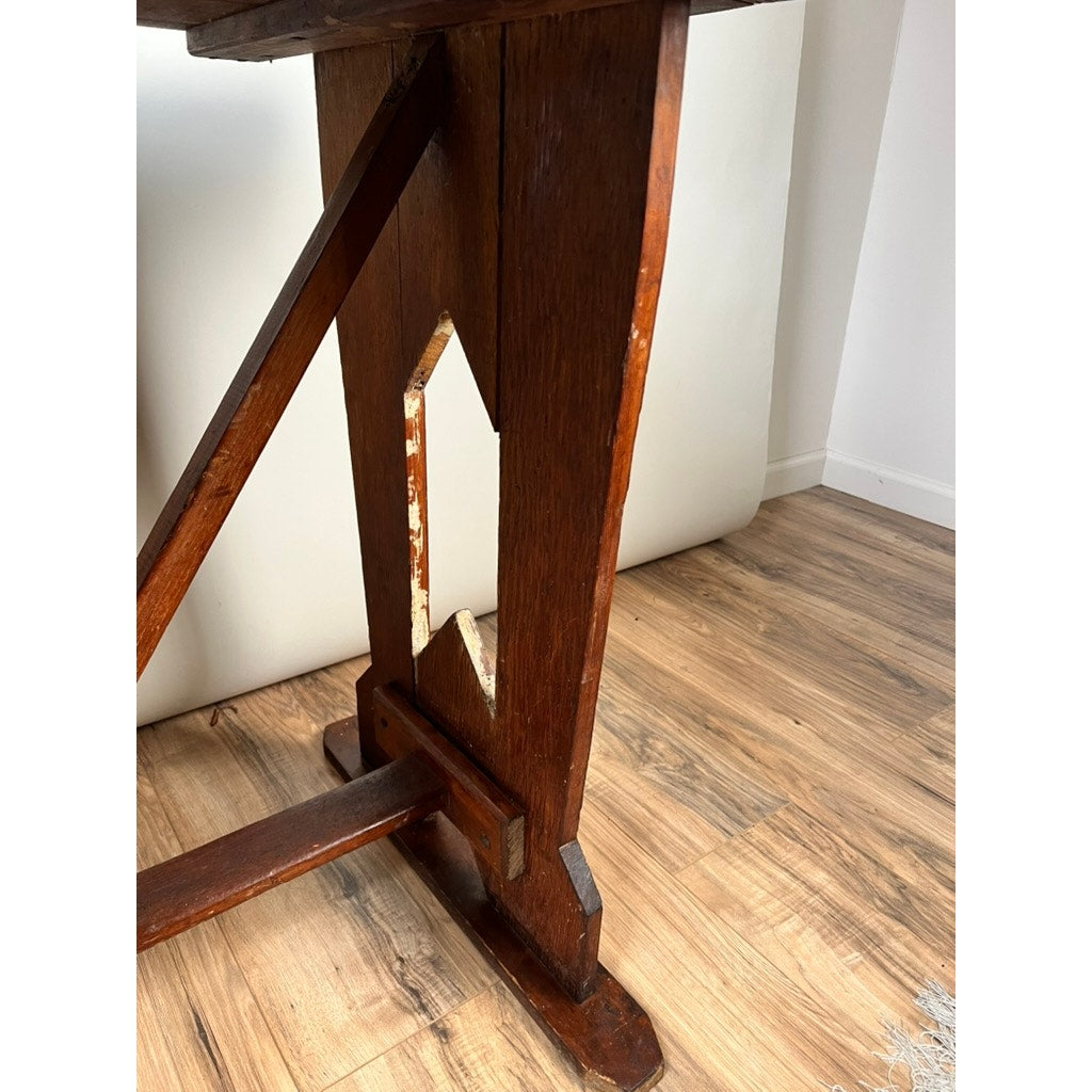 Close-up of an Antique Rustic Italian Fratino Trestle Table c. Late 19th Century, showing a solid wood leg with geometric cutout detail and rich reddish-brown finish, reflecting classic Italian craftsmanship.