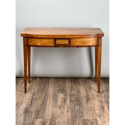 An Antique Federal Hepplewhite Tiger Maple Game Table c. 1830 by Pearl City Antiques, featuring tapered legs and a single drawer, is displayed against a plain light gray wall on a wood-patterned floor.