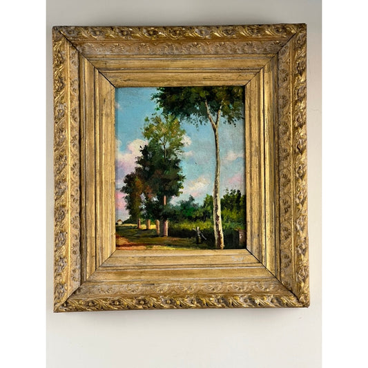 A gold ornate frame displays the “Sunny Tree Lined Path” painting by Pearl City Antiques—an antique Continental School oil on board from the early 20th century. The unsigned artwork, featuring tall trees, green grass, a wooden fence, and a blue sky with pink clouds, hangs on a plain white wall and captures timeless elegance.