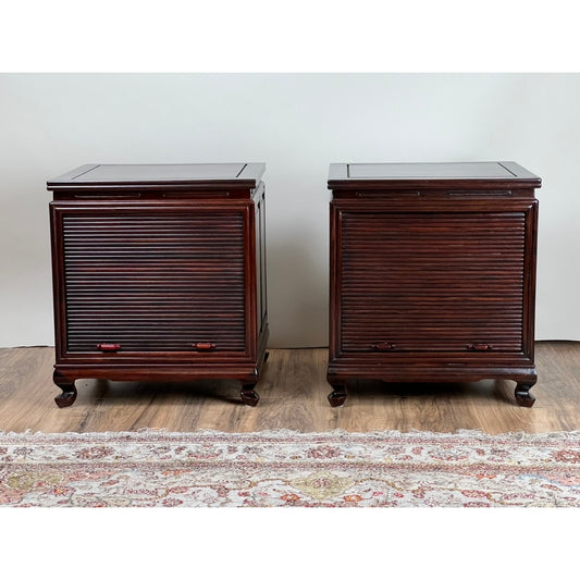 A pair of Vintage Solid Rosewood Chinese Tambour Four Drawer End Tables from Pearl City Antiques, featuring dark wood and roll-top tambour doors, are positioned side by side on a wooden floor with a patterned rug in front.