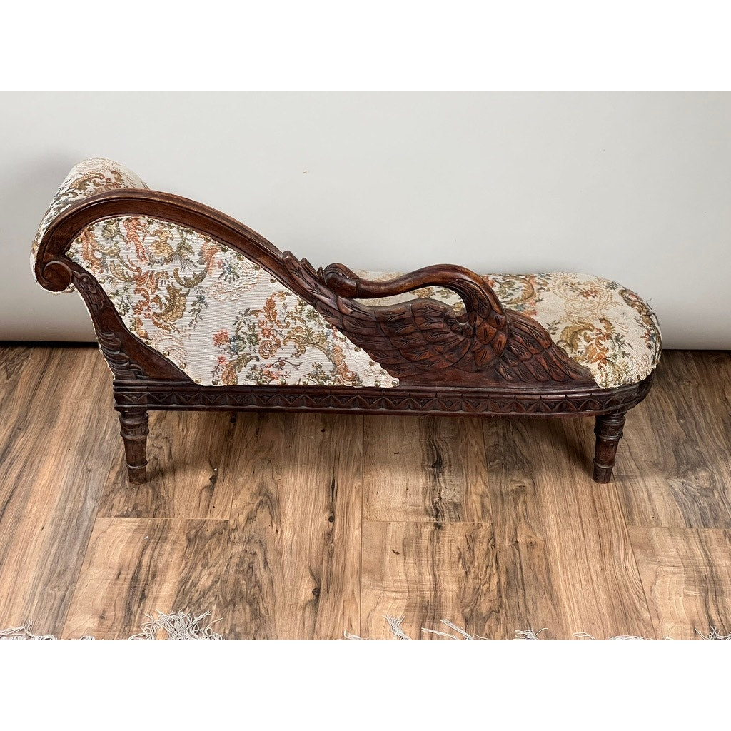 A Vintage Victorian Fainting Couch Style Dog Bed with floral upholstery, a dark carved wood frame, and a swan-shaped armrest rests on a wooden floor against a plain white wall. Brand: Unknown.