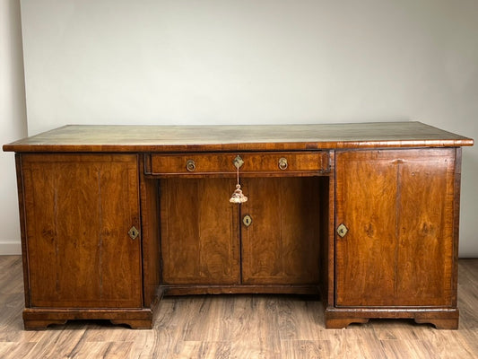 The Large Antique George II Mahogany Desk c. Mid 18th Century by Pearl City Antiques features a polished finish, two cabinets per side, a central drawer with tassel key, and a flat top—an elegant Georgian piece perfect for any space.