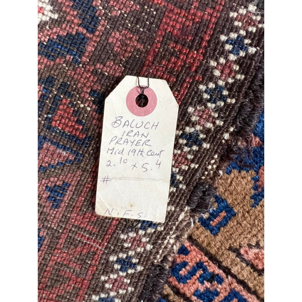 A handwritten tag on this Antique Persian Baluch Prayer Rug with Mina Khani field (c. Mid 19th Century, 2’10 x 5’4) shows additional markings and a top hole—an authentic collectible without a known brand.