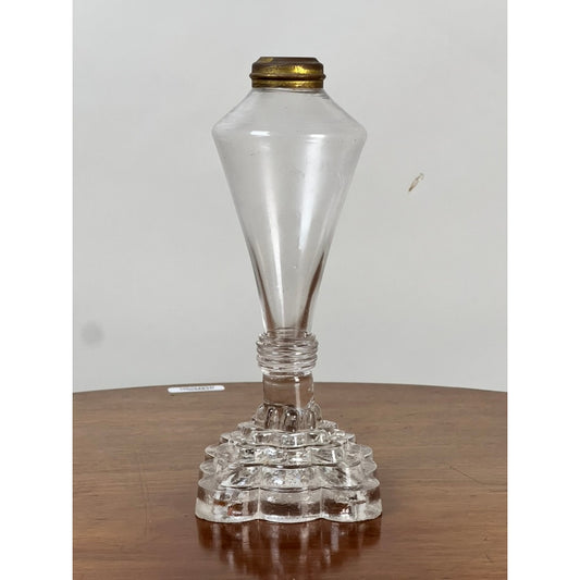An Attributed Boston & Sandwich Pressed Glass Boudoir Fluid Lamp, Circa 1850, from Pearl City Antiques sits on a wooden surface against a plain white background. The vintage clear glass lamp features a brass cap and a geometric pressed glass base reminiscent of classic Boston & Sandwich designs.