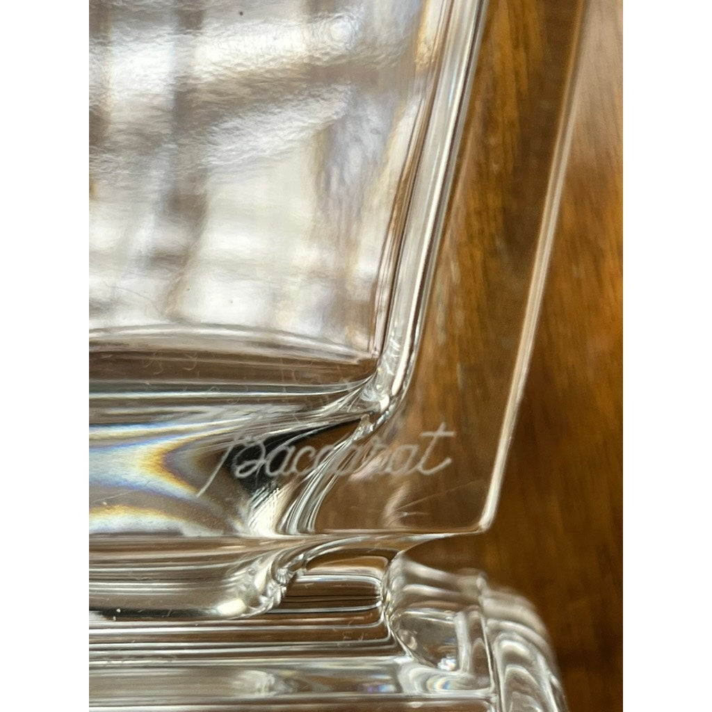 Close-up of the base of the Vintage Baccarat Crystal Pearl Vase, featuring "Baccarat" etched in cursive. The blurred, warm brown background accentuates the refined elegance and timeless French design of this Baccarat piece.