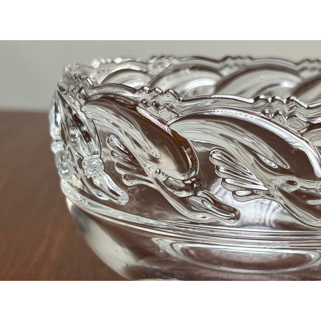 Close-up of a Vintage Tiffany & Co. Mid-Century Modern Crystal Dolphin Pattern Footed Bowl by Tiffany & Co., featuring an elegant footed design, shown on a wooden surface.