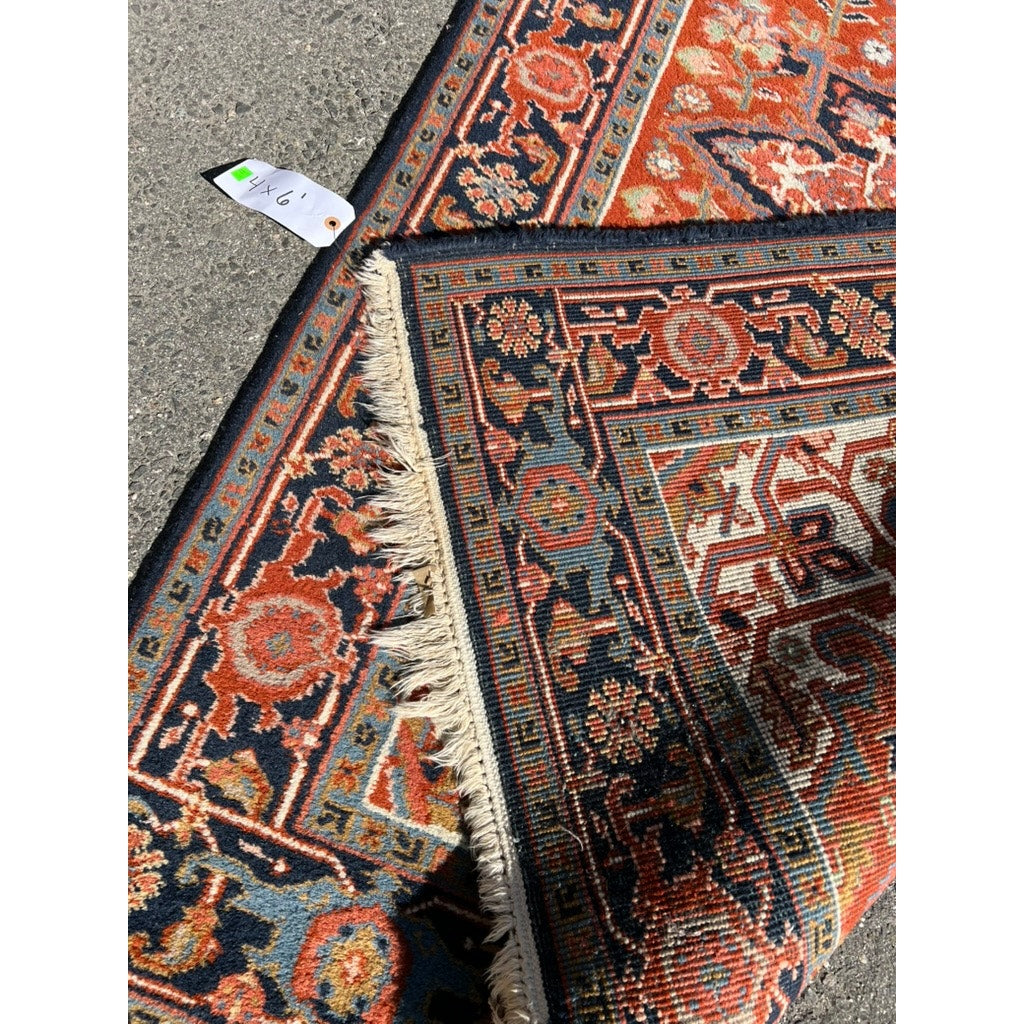 A close-up shows two overlapping patterned rugs on concrete, featuring a Vintage Heriz Persian Area Rug 4x6 with red, blue, gold, and cream geometric and floral designs. A $67 price tag is attached to one corner. Brand is unknown.