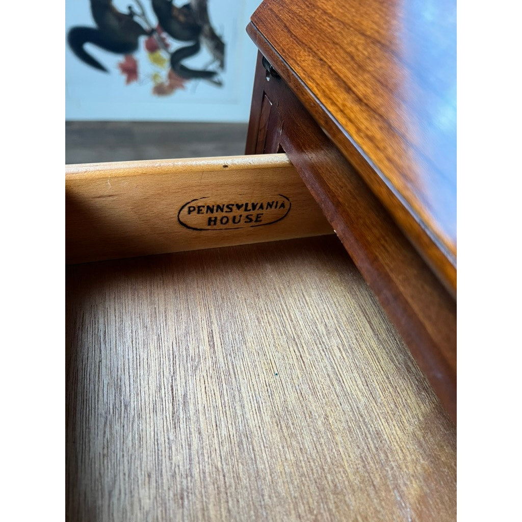 Open solid cherry drawer stamped with Pennsylvania House, part of a polished Vintage Solid Cherry Queen Anne Style Slant Front Secretary Desk by Pennsylvania House, with a blurred decorative wall in the background.