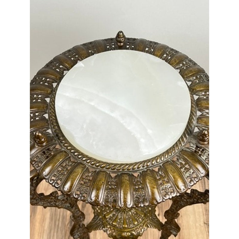 An Antique Victorian Bronze and Onyx Stand (late 19th c.) with ornate carvings and a white onyx top, reminiscent of a classic bronze side table, is shown positioned on a wooden floor.