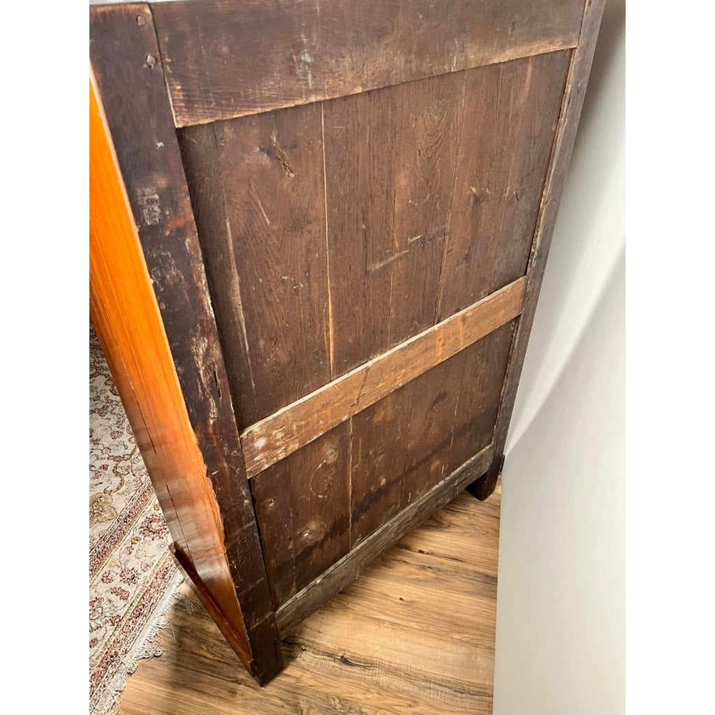 The image shows the back of an Antique French Empire Secrétaire Abattant with ormolu mounts (mid 19th century), revealing aged wood, panels, and support beams. Also visible are parts of a patterned rug and a wooden floor. Brand: None/Unknown.