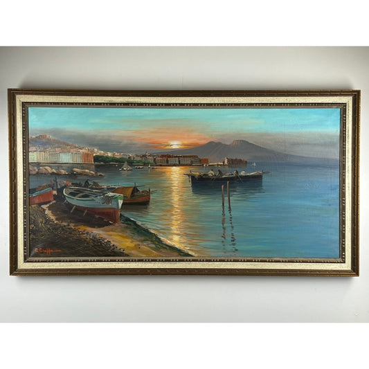 Experience the timeless beauty of Pearl City Antiques’ “Naples Harbor” — a signed oil on canvas by C. Ciappa (28 x 52), featuring tranquil waters at sunset, boats near the shore, distant buildings, and hazy mountains, elegantly framed and evocative of classic Neapolitan coastal scenes.