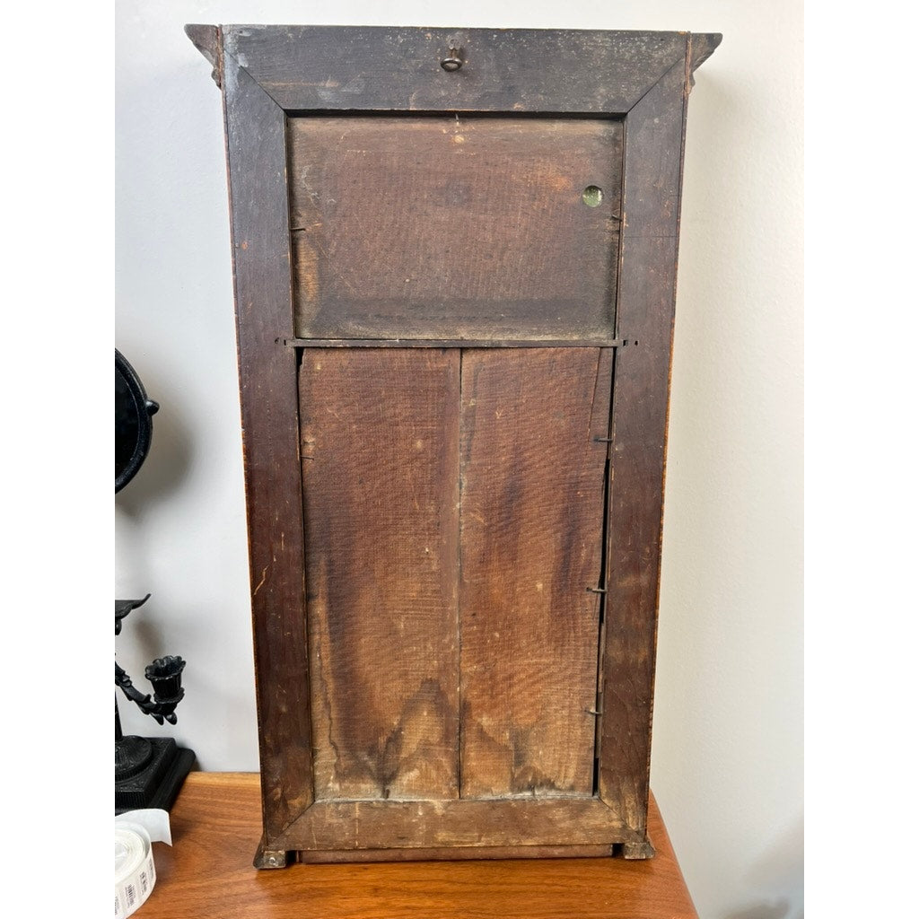 A fine antique Federal period tiger maple two-panel mirror, circa 1820, with visible grain and scratches, stands on a wooden surface against a light wall; brand name unknown.