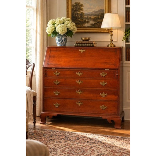 A Chippendale Cherry Slant-Front Desk with Ogee Bracket Feet, possibly Connecticut River Valley, circa 1770–1790, is an 18th-century cherry wood slant-front desk featuring four drawers, brass pulls, and ogee bracket feet.
