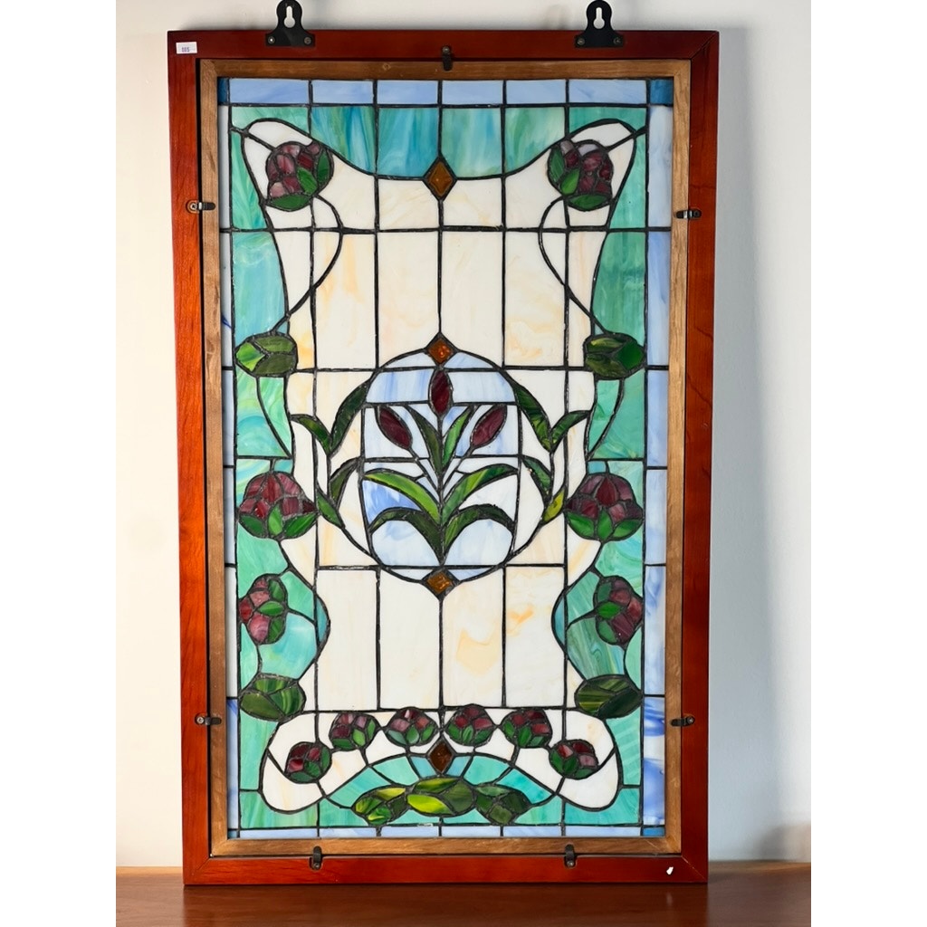 The Vintage Stained Glass Wall Hanging 32x20 features an Art Nouveau floral design with green stems, red flowers, and blue accents in a wooden frame, set against frosted and light-colored glass. Brand: None and/or Unknown.
