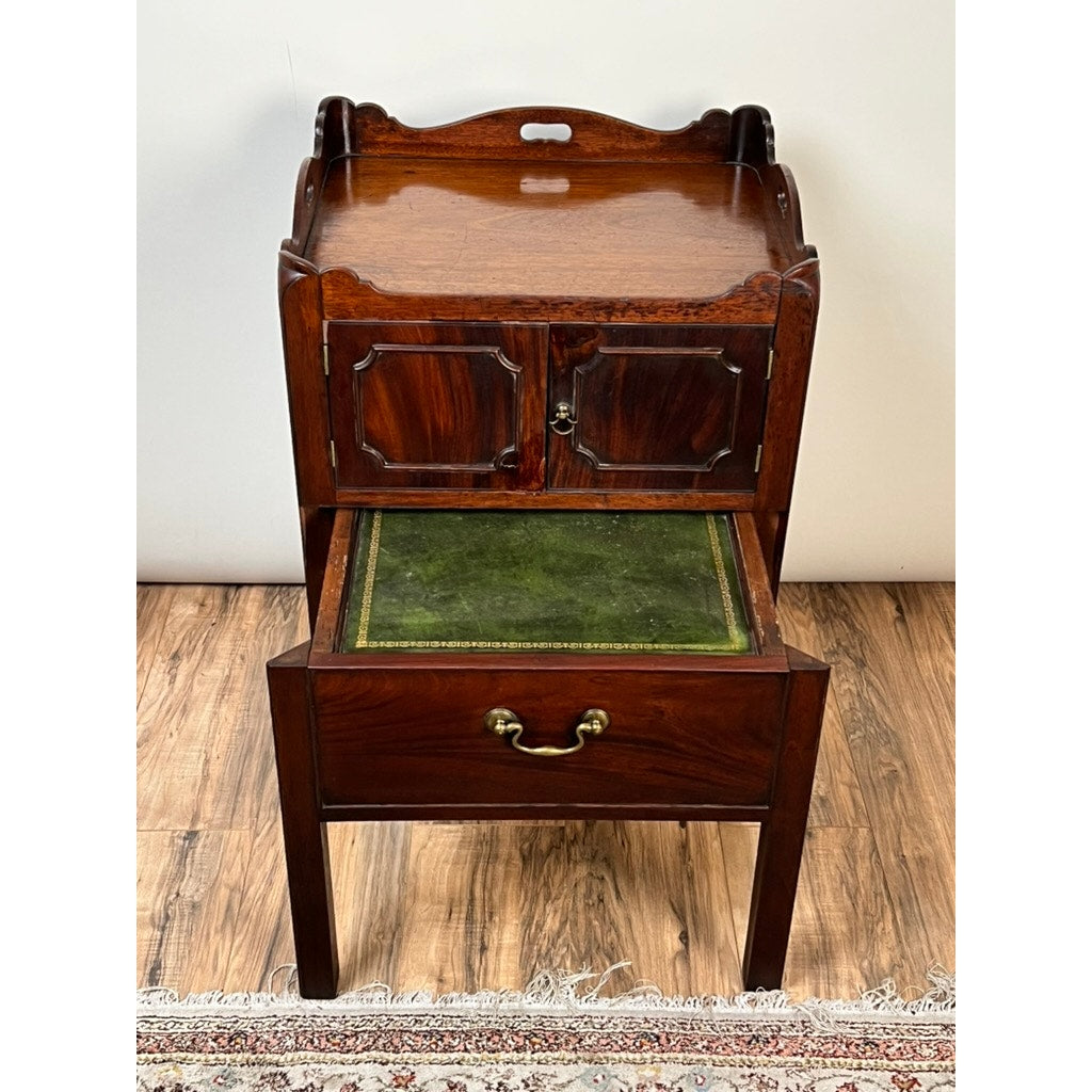 Antique George III bedside commode, late 18th century, with a green leather pull-out writing surface, small two-door cabinet, brass lower drawer handle, mahogany finish, and four legs—an elegant example of period furniture.
