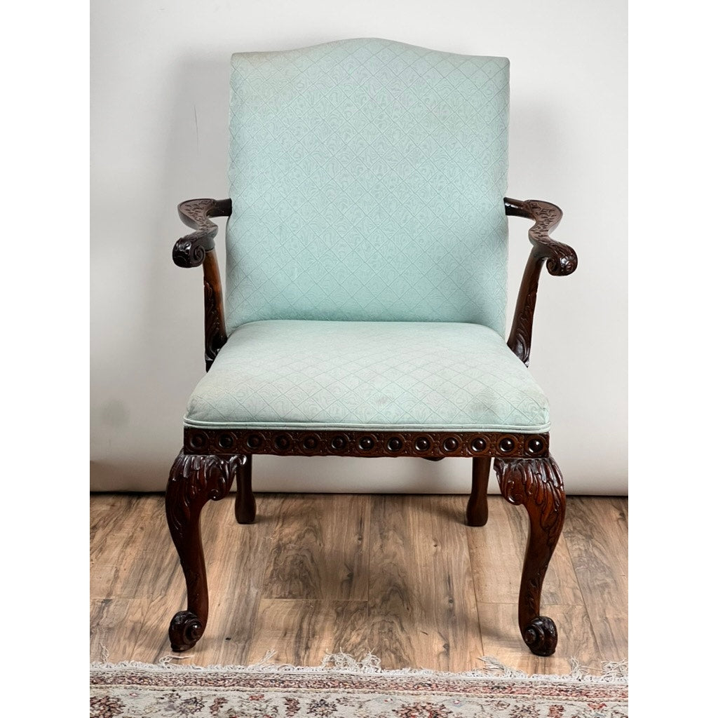 Antique George II Mahogany Gainsborough open arm chair, mid-19th century, featuring cabriole legs, carved arms, and light blue upholstery on seat and backrest; shown with a wooden floor and patterned rug. Brand: Unknown.