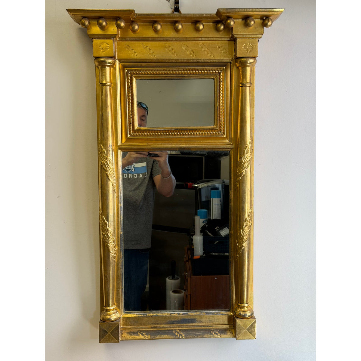 An American Federal Giltwood Two-Plate Looking Glass, probably Massachusetts, circa 1810–1830, featuring two vertical glass panels framed by columns and a cornice with decorative spheres.