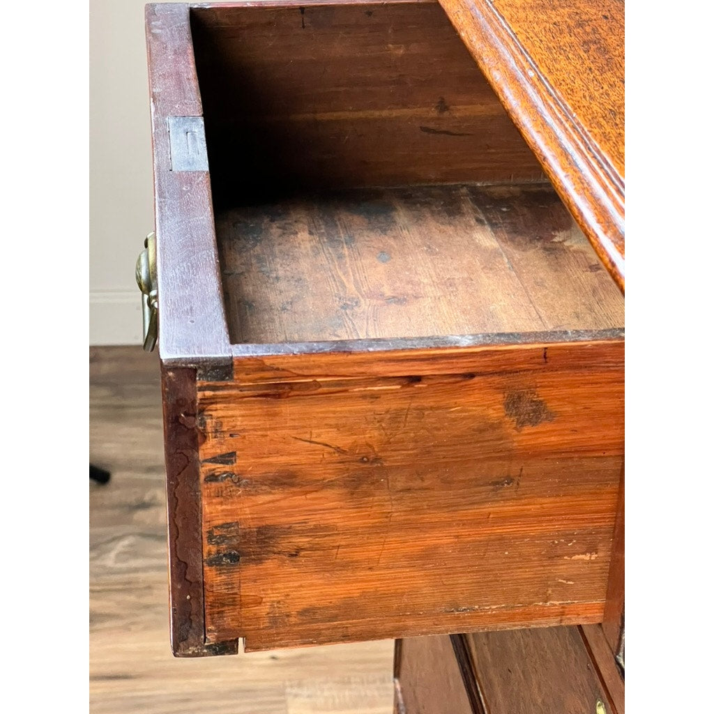 A close-up of an open, empty drawer with visible scratches and worn edges, belonging to a Late Georgian English Mahogany Chest of Drawers (circa 1780–1810), shown on a wooden floor.