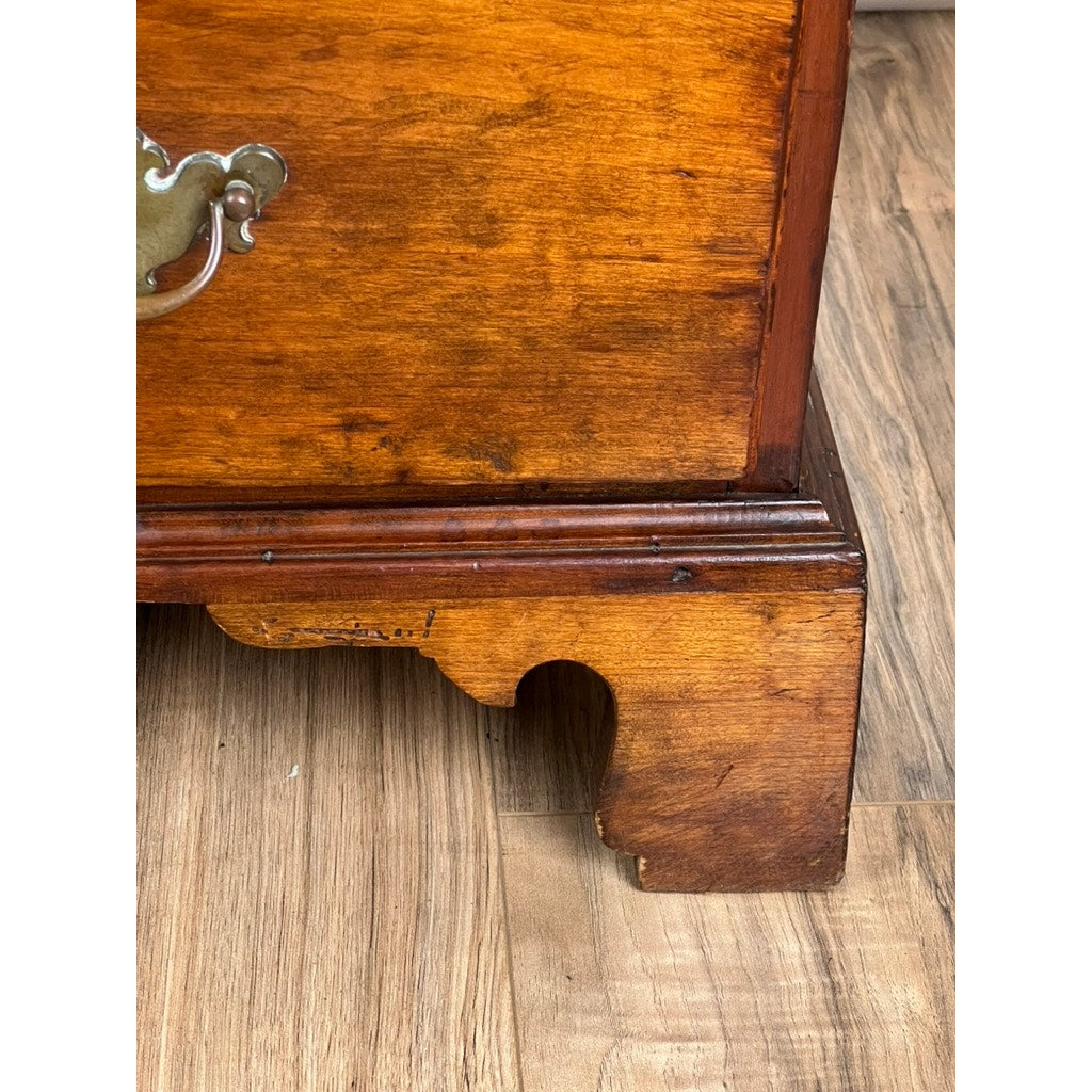 Close-up of the bottom corner of an Antique George IV Butlers Secretary (early 19th century), highlighting its detailed mahogany grain, brass handle, decorative trim, and shaped leg on a wood floor—an elegant period piece.