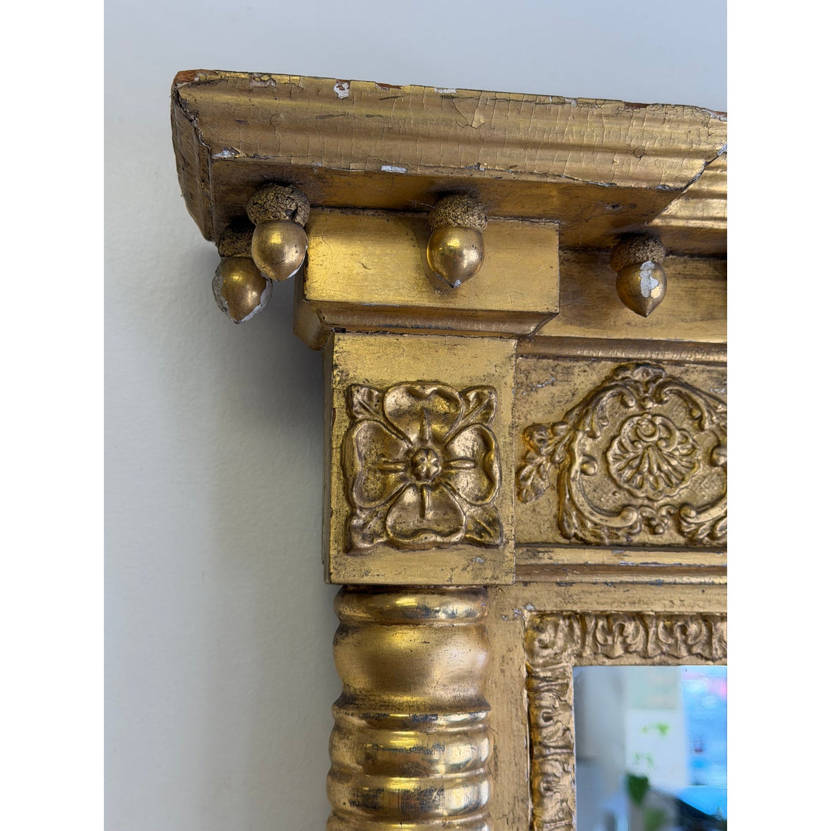 Detail of an American Federal Giltwood Pier Mirror, Possibly Massachusetts or New York, circa 1815–1830, featuring a cornice with acorn-shaped pendants and relief carvings of floral and foliate motifs.