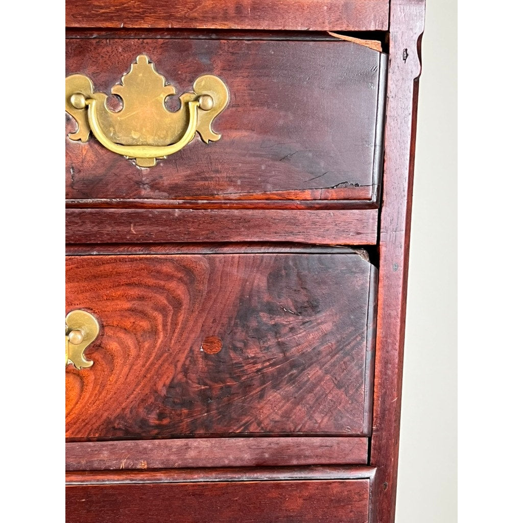 Close-up of an Antique Queen Anne Walnut Chest on Frame with Drake Feet, probably Irish c. late 18th century. The rich walnut finish and ornate brass handles highlight its grain patterns and elegant age. Brand unknown.