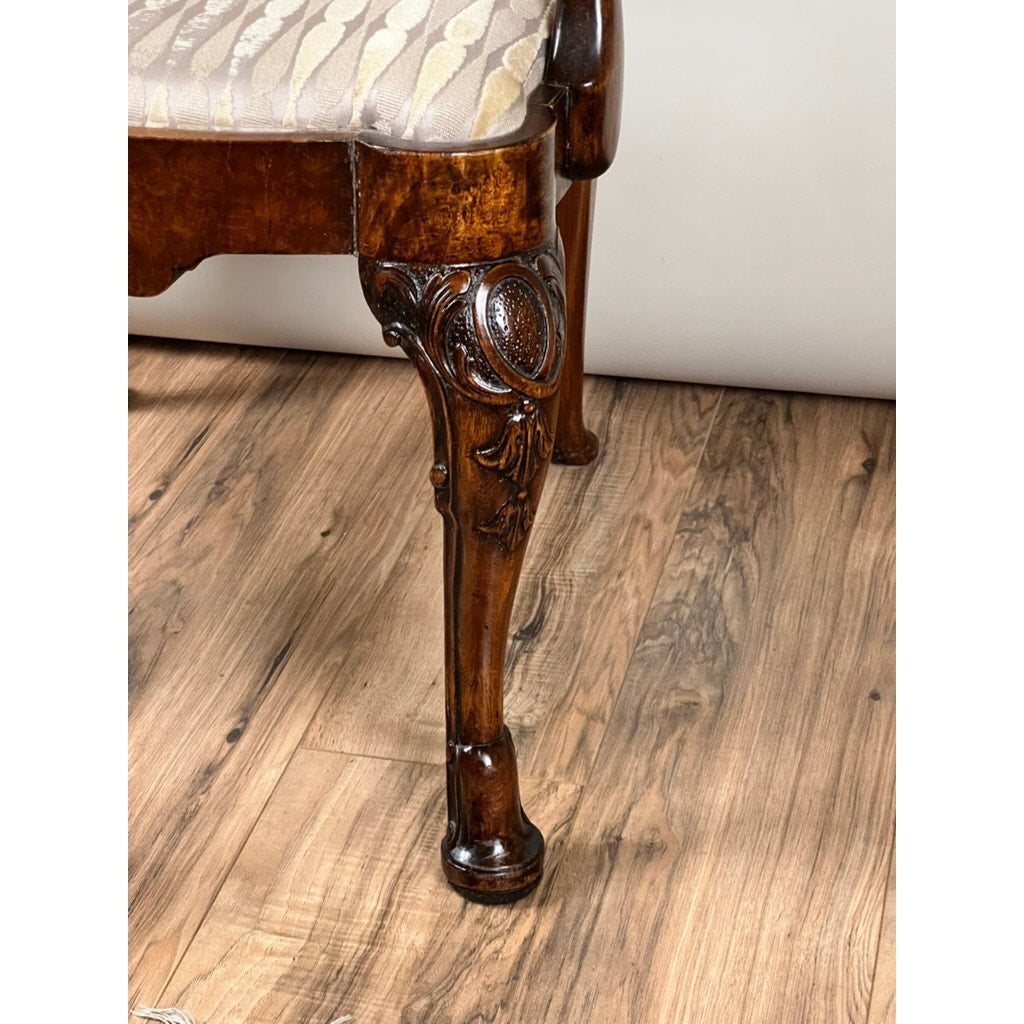 Close-up of an Antique George III Mahogany Open Arm Chair (late 18th century) showing its detailed Chippendale-style carvings, dark polished finish, and patterned upholstered seat, set on a wooden floor. Brand unknown.