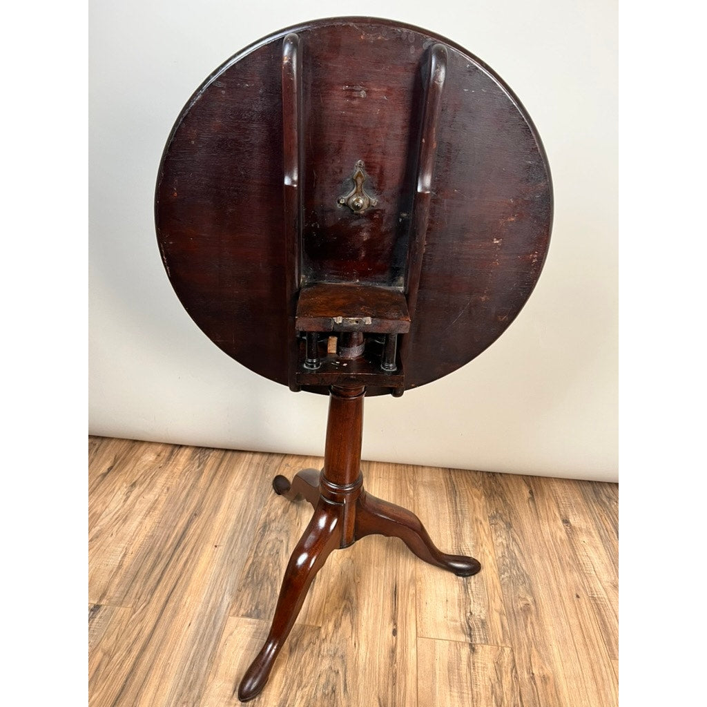An Antique Queen Anne Mahogany Birdcage Tilt Top Breakfast Table (early 19th century) with a flip-top and three curved legs is shown upright on a wood floor against a light-colored wall. Brand: Unknown.