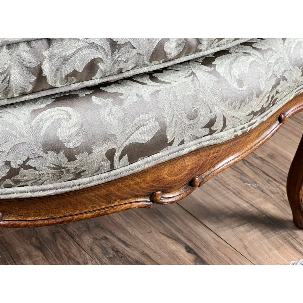 Close-up of an Antique French Louis XV Rococo Style Bergère Arm Chair, c. mid 19th century, featuring a carved walnut frame and newer damask upholstery, set on a wood floor. Brand: None/Unknown.