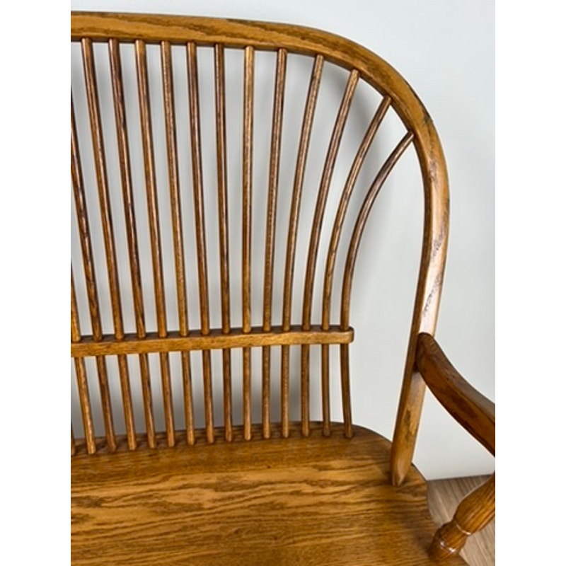 Side view of vintage oak Windsor bench with wide seat