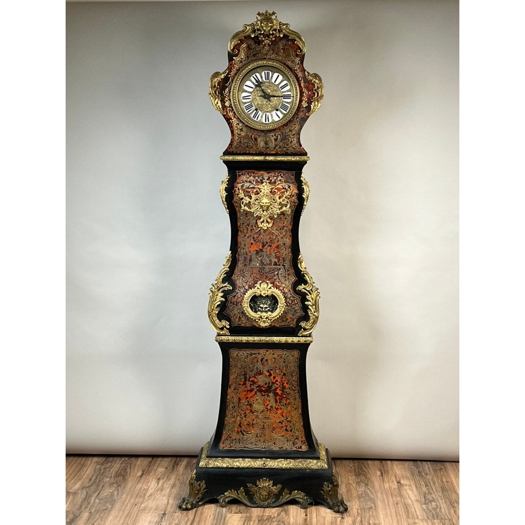 A monumental French Napoleon III Boulle marquetry floor clock with ormolu mounts, dating from circa 1865–1885, featuring a striking black and red body with intricate gold detailing, Roman numerals on its clock face, and standing on a wooden floor against a plain background.