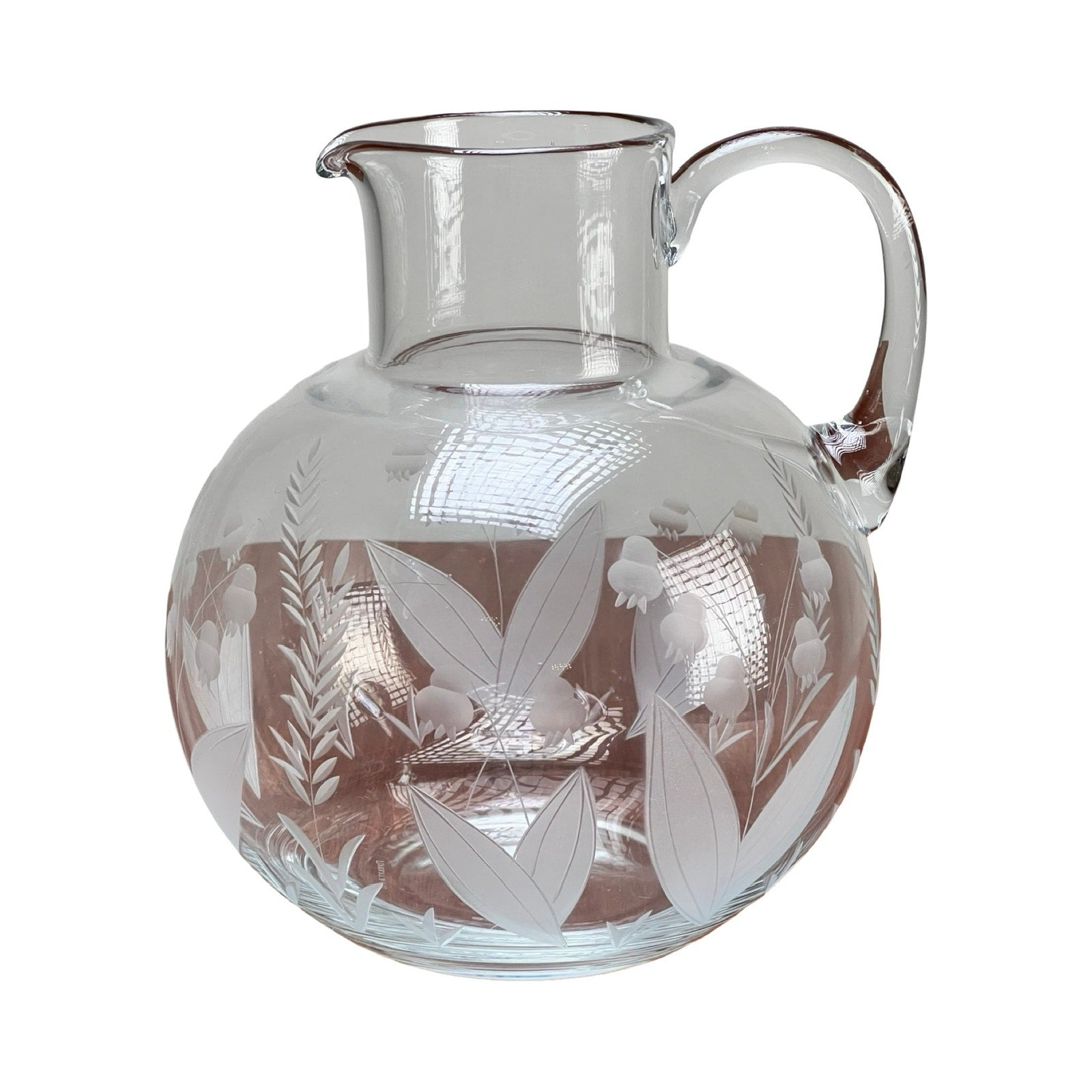 This Vintage Tiffany & Co. etched crystal pitcher features a lily of the valley floral motif, with a handle and spout for elegant serving.