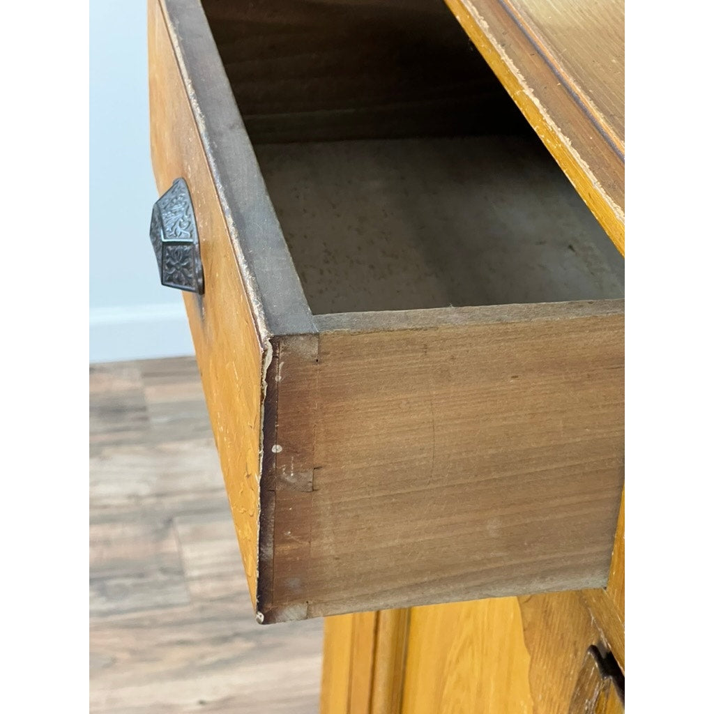 A close-up of an open drawer with a metal handle and dovetail joints on the Antique Victorian Grain Painted Country Jelly Cupboard c. 1870, showing its light grain-painted finish atop a wood floor.