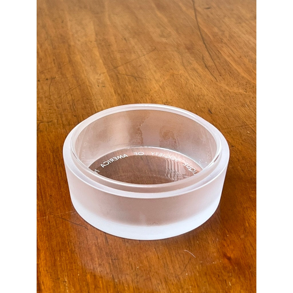 A Vintage Lalique France Ballerina Frosted Crystal Covered Powder Box by Lalique sits on a wooden surface, its frosted edges and engraved details visible through the clear crystal, evoking elegant French decorative style.