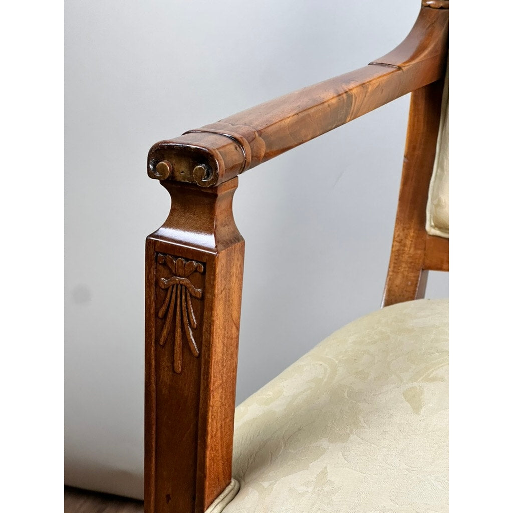 Close-up of the carved wooden armrest on an Antique French Directoire Style Fauteuil Open Arm Chair in Sapelle Mahogany, c. late 19th century, highlighting decorative details and light beige patterned fabric seat. Brand: Unknown.