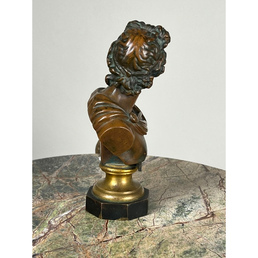 The Antique Small Bronze of “the Apollo Belvedere” with Vienna Foundry Mark features a neoclassical bust with curly hair, turned sideways on a round gold-and-black pedestal, displayed on a marble-patterned surface against a light grey backdrop.