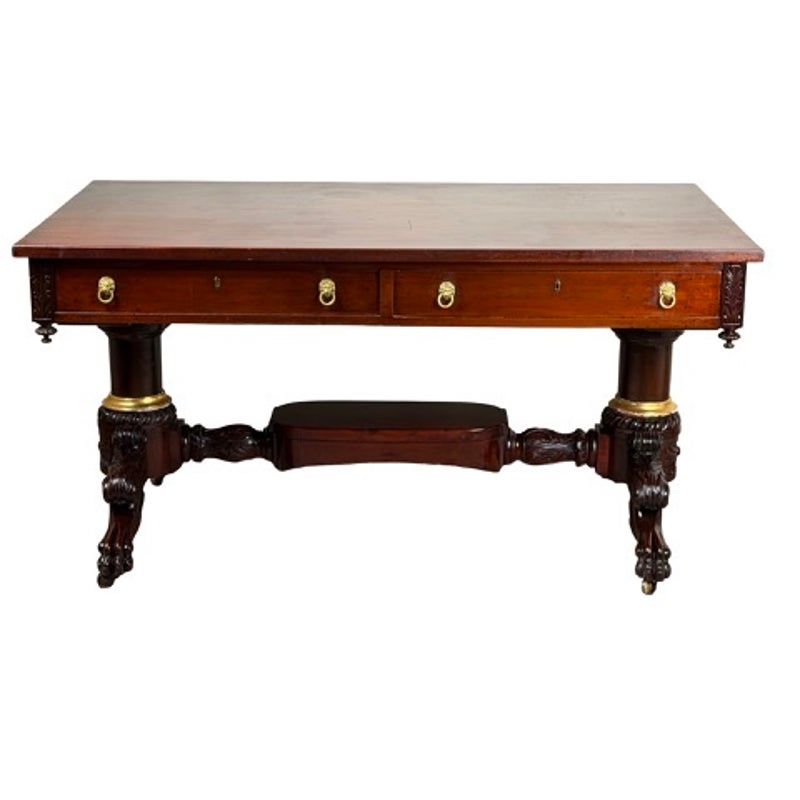 New York Classical Revival Carved Mahogany Double-Pedestal Library Table by Ernest F. Hagen, featuring two drawers with brass lion-head pulls, supported by two carved pedestals with decorative claw feet.