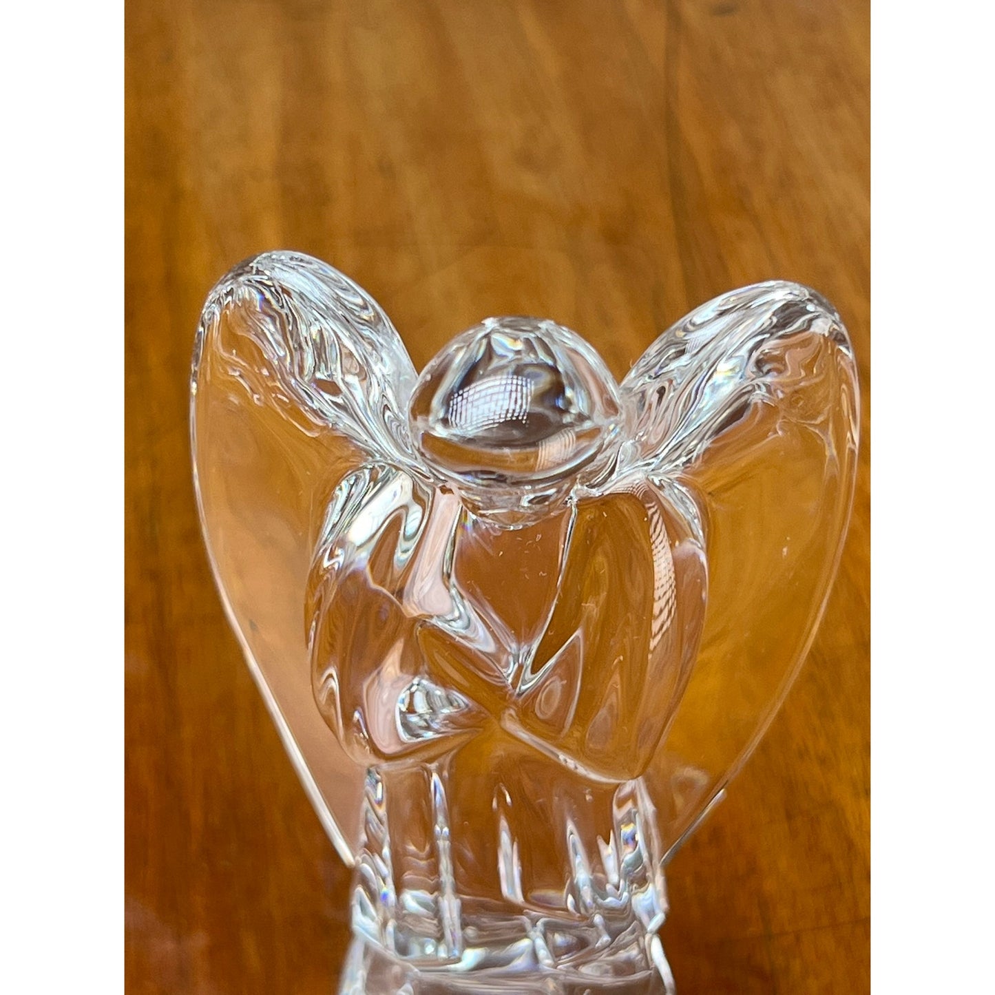 The Vintage Baccarat Crystal Angel by Baccarat, crafted from clear glass with outstretched wings, exudes timeless elegance as it graces any polished wooden surface.