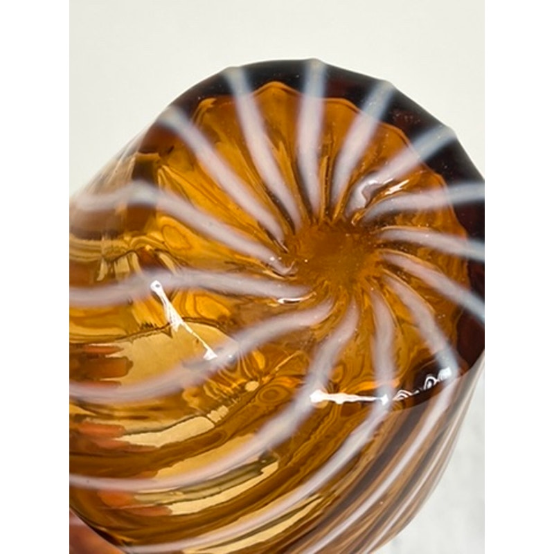 A close-up of the Vintage Fenton Autumn Gold Opalescent Glass Spiral Pattern Pitcher shows its raised spiral ridges and opalescent glow, highlighting this collectible piece’s charm against a light background.