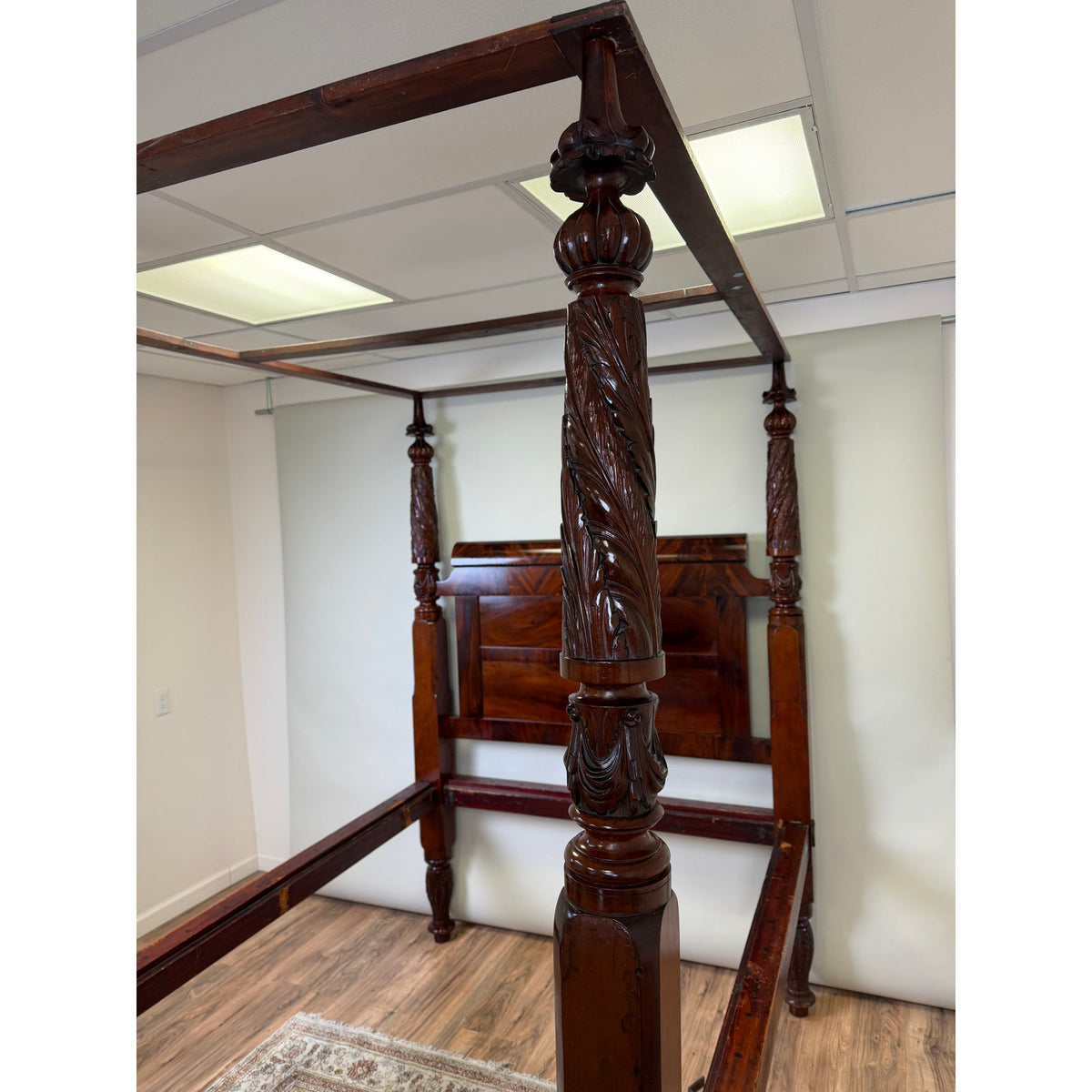 An American Classical Carved Mahogany Four-Poster Tester Bed, possibly New York, circa 1825–1840, featuring elaborately carved dark mahogany posts and a paneled headboard.
