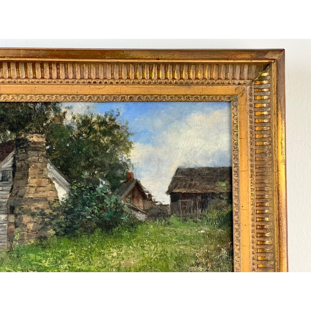 Close-up of an ornate gold frame with the upper left section of an Antique American School Farmstead Landscape Oil Painting, Circa 1900, showing rustic buildings, green grass, and trees beneath a blue sky. Brand unknown.