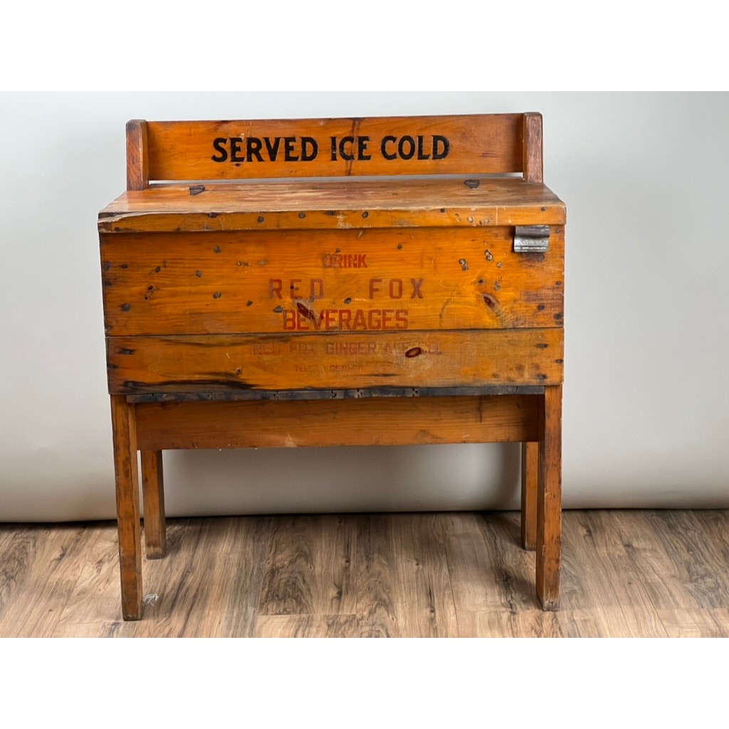 An Antique Tin Lined Pine General Store Red Fox Ginger Ale of Rhode Island Cooler c. 1930, with tall legs and faded "SERVED ICE COLD" marking, recalls early 20th-century soda coolers from Red Fox.