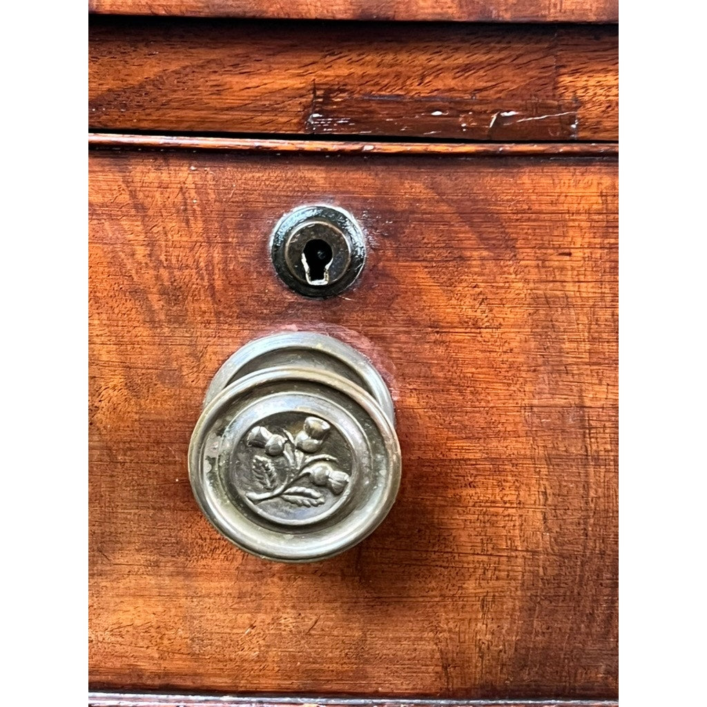 Close-up of an Antique George III Mahogany Bowfront Chest on French Feet (late 18th c.), featuring a round brass floral knob, keyhole, and rich reddish-brown mahogany grain characteristic of Georgian period furniture.