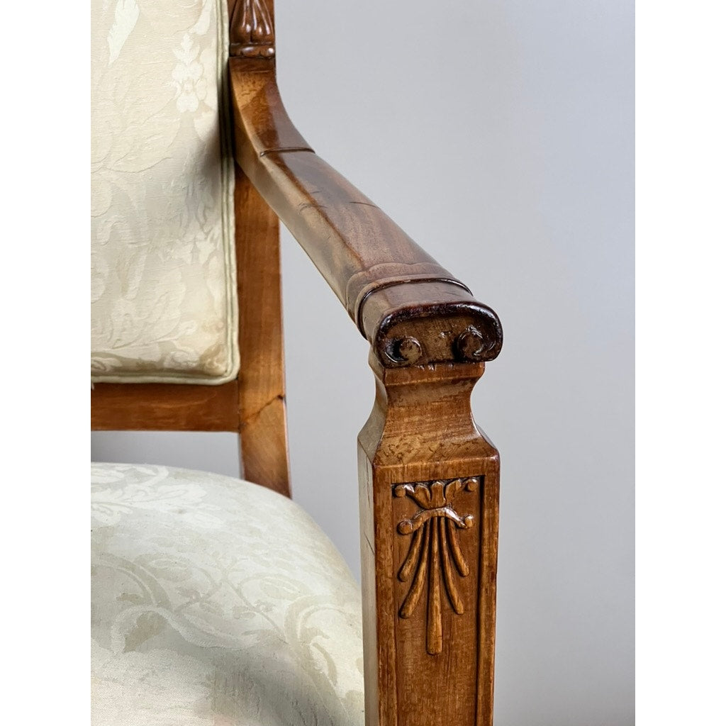 Close-up of a wooden armrest on an Antique French Directoire Style Fauteuil Open Arm Chair in Sapelle Mahogany, c. Late 19th Century, featuring carved details and light floral-patterned upholstery with a polished finish. Brand unknown.