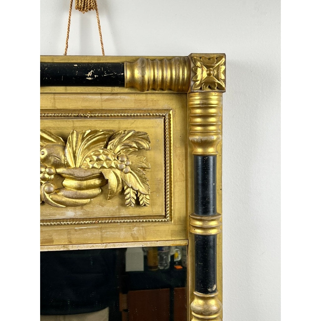 Close-up of an Antique Federal Period Giltwood Mirror, c. 1830, featuring rosette corners, intricate cornucopia carvings, a decorative column, and a hanging rope; brand unknown.