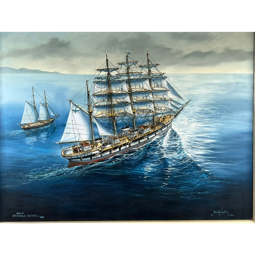 “Barque Archibald Russell 1905” is a 1984 signed oil on canvas by John Richard Perry, featuring two tall-masted sailing ships with white sails gliding over calm blue waters beneath a partly cloudy sky and distant mountains.