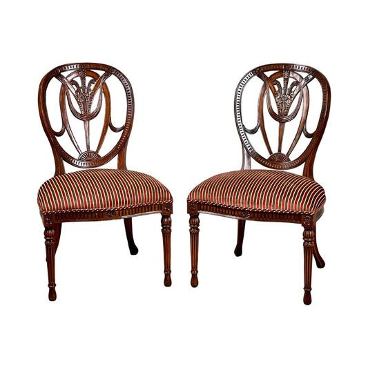 A Vintage Pair Wheel Back Side Chairs by Ardley Hall features ornate carved backs and red, white, and black striped seats, highlighting classical English design against a white backdrop.