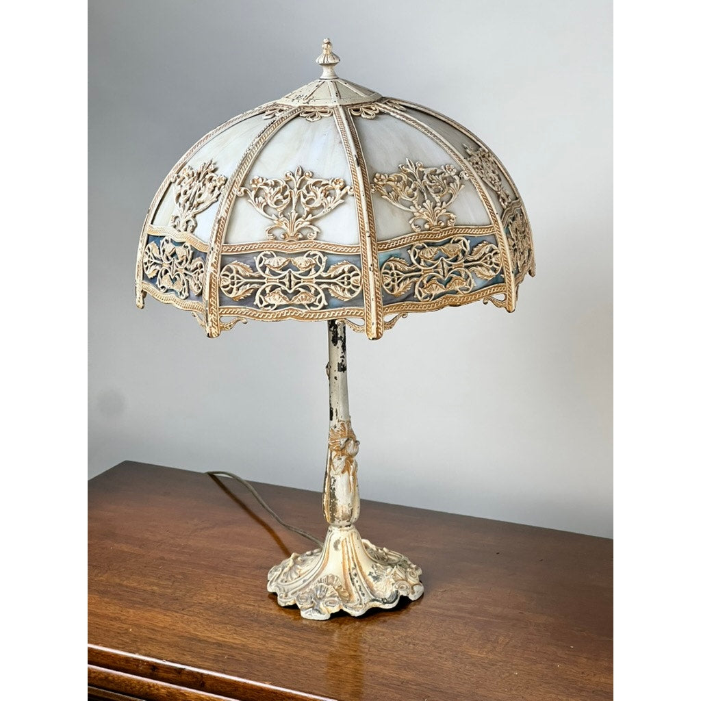 The Vintage Art Nouveau Slag Glass Two-Light Table Lamp (c. 1935–1955) features a dome-shaped stained glass shade with intricate metal floral designs and an ornate decorative base, perfect for adding elegant lighting to any space. Brand: None/Unknown.