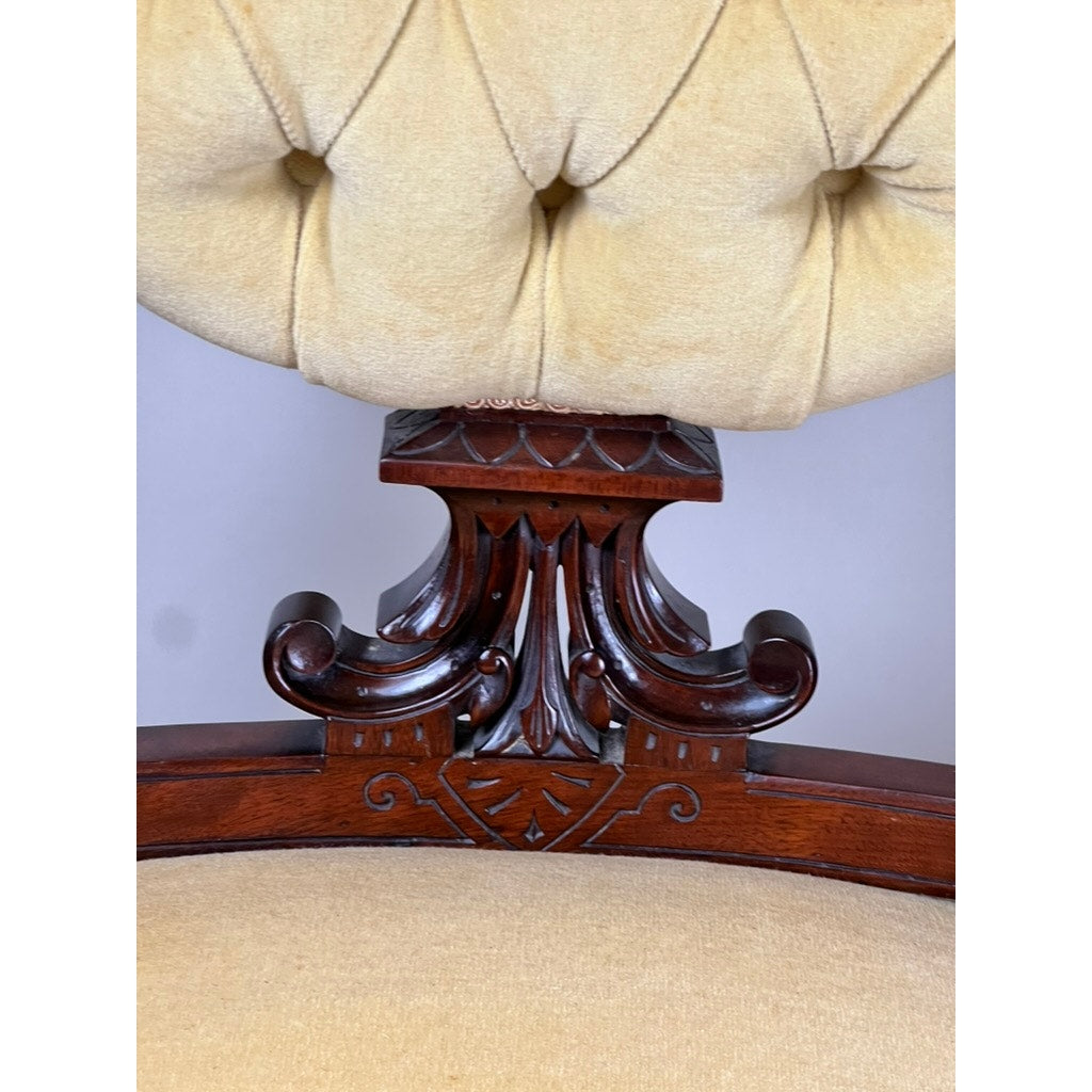 Close-up of a fine antique pair of Renaissance Revival walnut side chairs attributed to John Jelliff, Newark c. 1880, with ornate carved frames and light beige tufted upholstery.